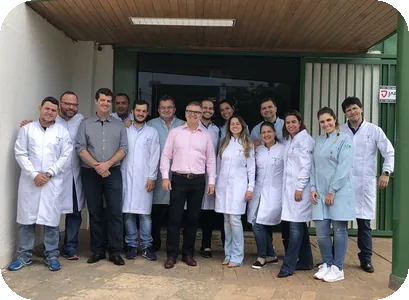 Turma de alunos de jaleco com os professores